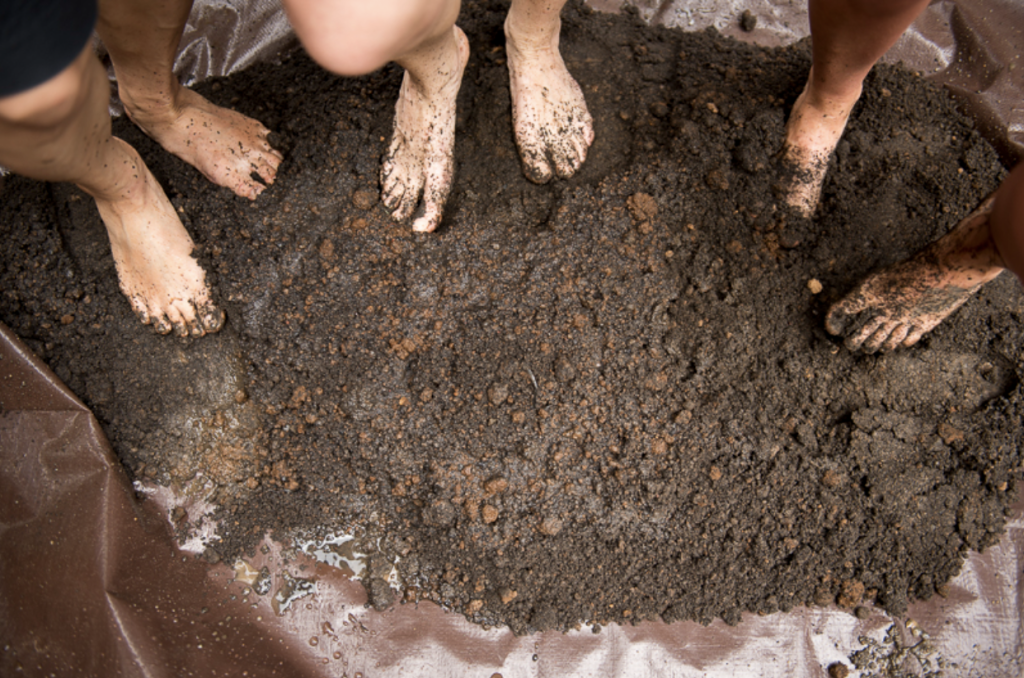 Process of preparing the mud mixture using hands and legs